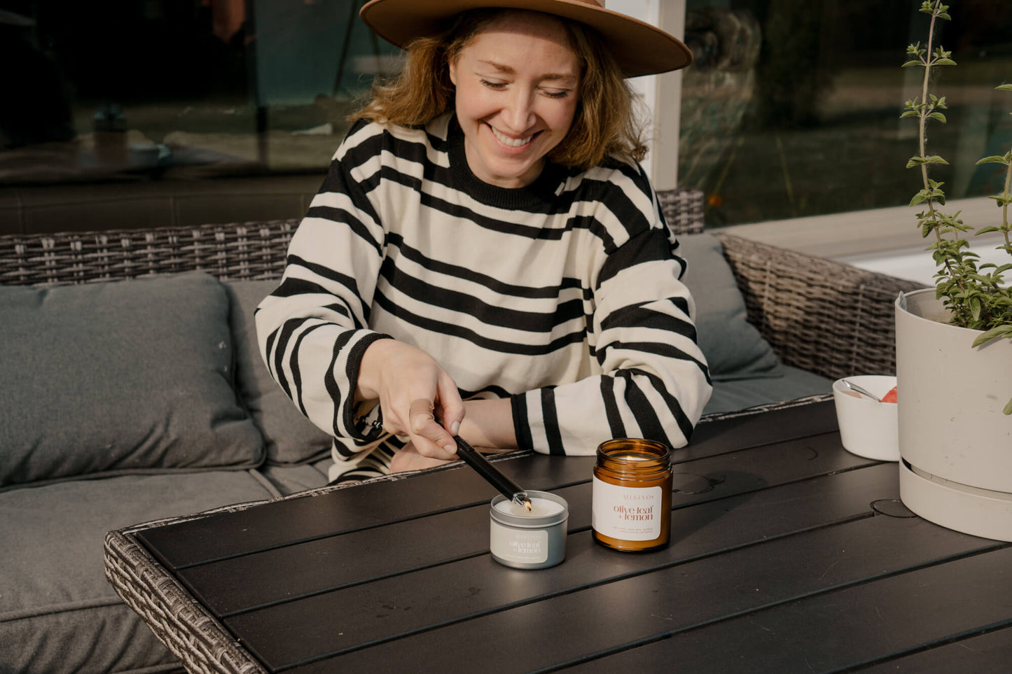 A woman lighting Misiyo candles on her outdoor deck