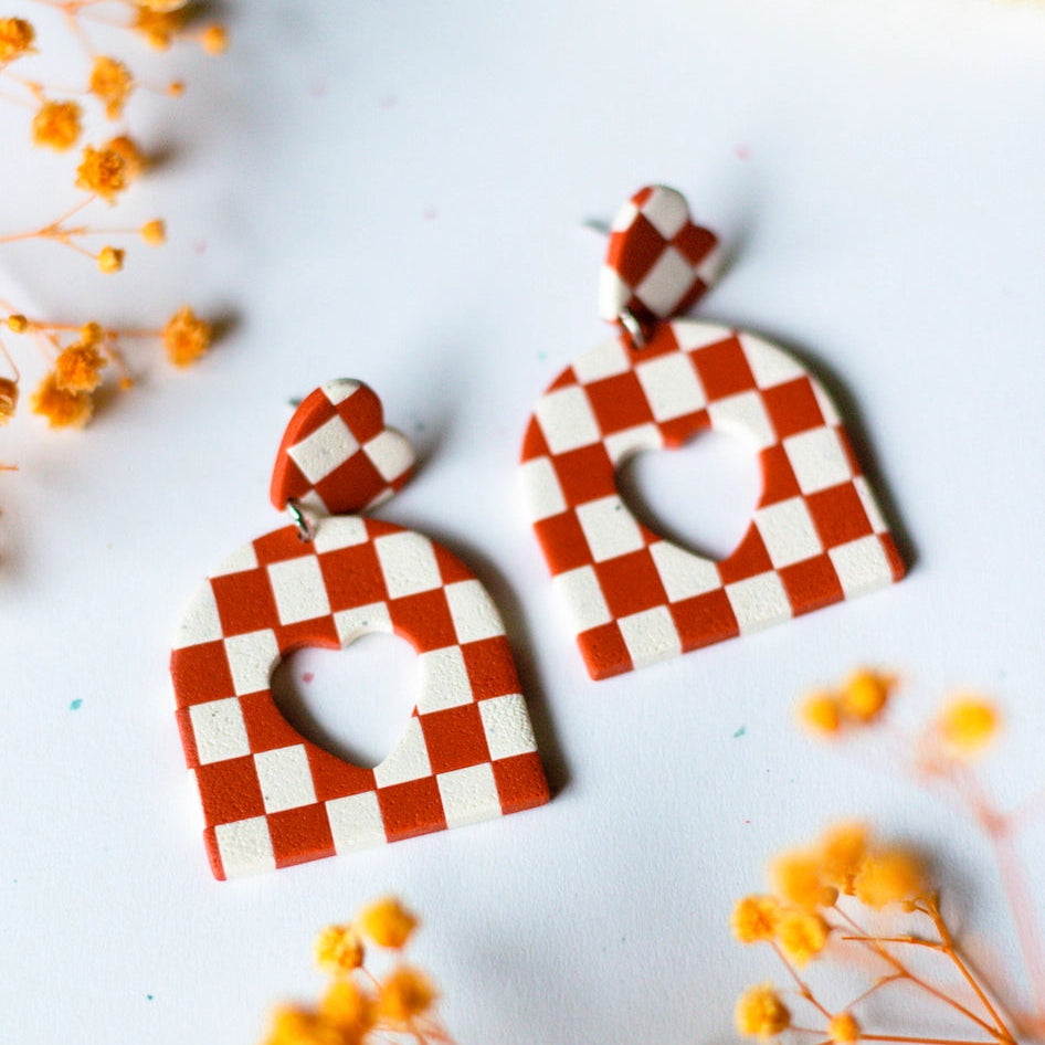 checkerboard heart cutout earrings made of ploymer clay on a white background