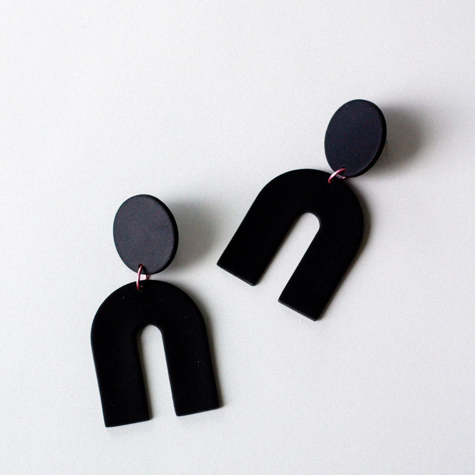 Black U-shaped earrings on a white background