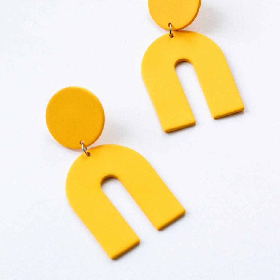 Yellow U-shaped earrings on a white background