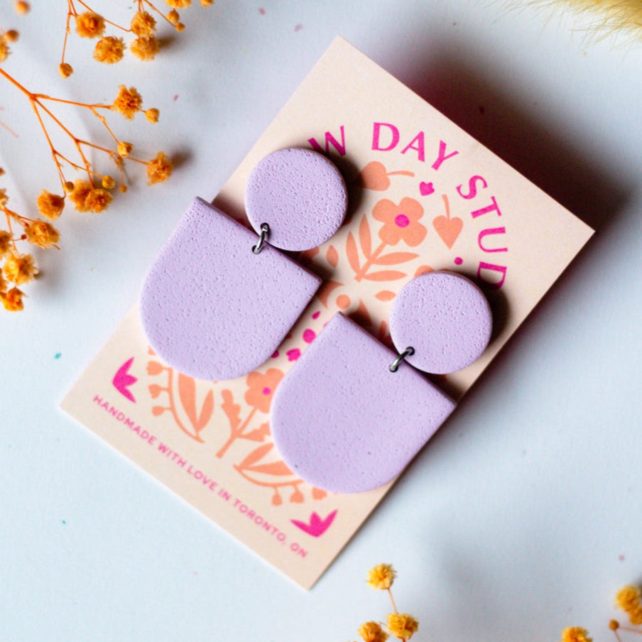 pair of purple arched handmade polymer cay earrings, lilac in colour