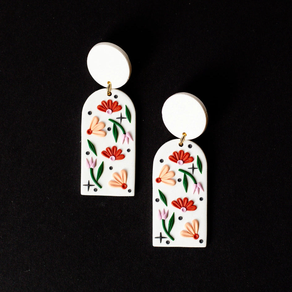 Pair of floral earrings on a black background