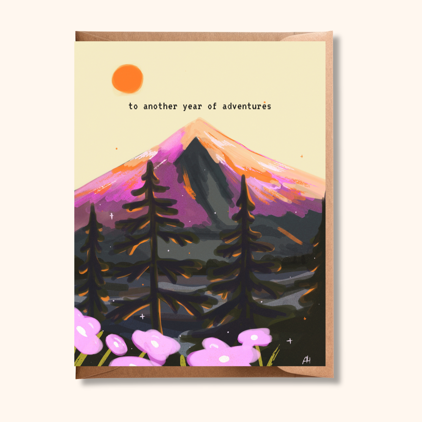 Brush & Bird's "To Another Year of Adventures" birthday greeting card illustrated with a moody mountain landscape, purple peaks, dark pine trees, and pink wildflowers under an orange sun, tucked into a kraft envelope — a perfect card for the outdoorsy adventurer in your life.
