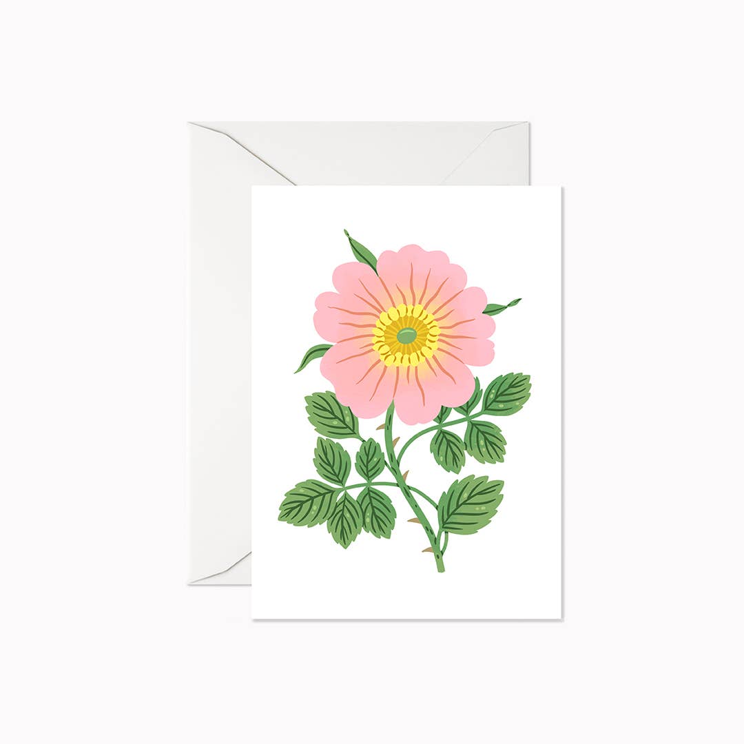 Pink Rose Mini Card by Linden Paper Co., featuring a bold botanical illustration of a single pink wild rose with green leaves on a white card, shown with a white envelope — a sweet mini card for gifting with flowers or small presents. Made in Canada.