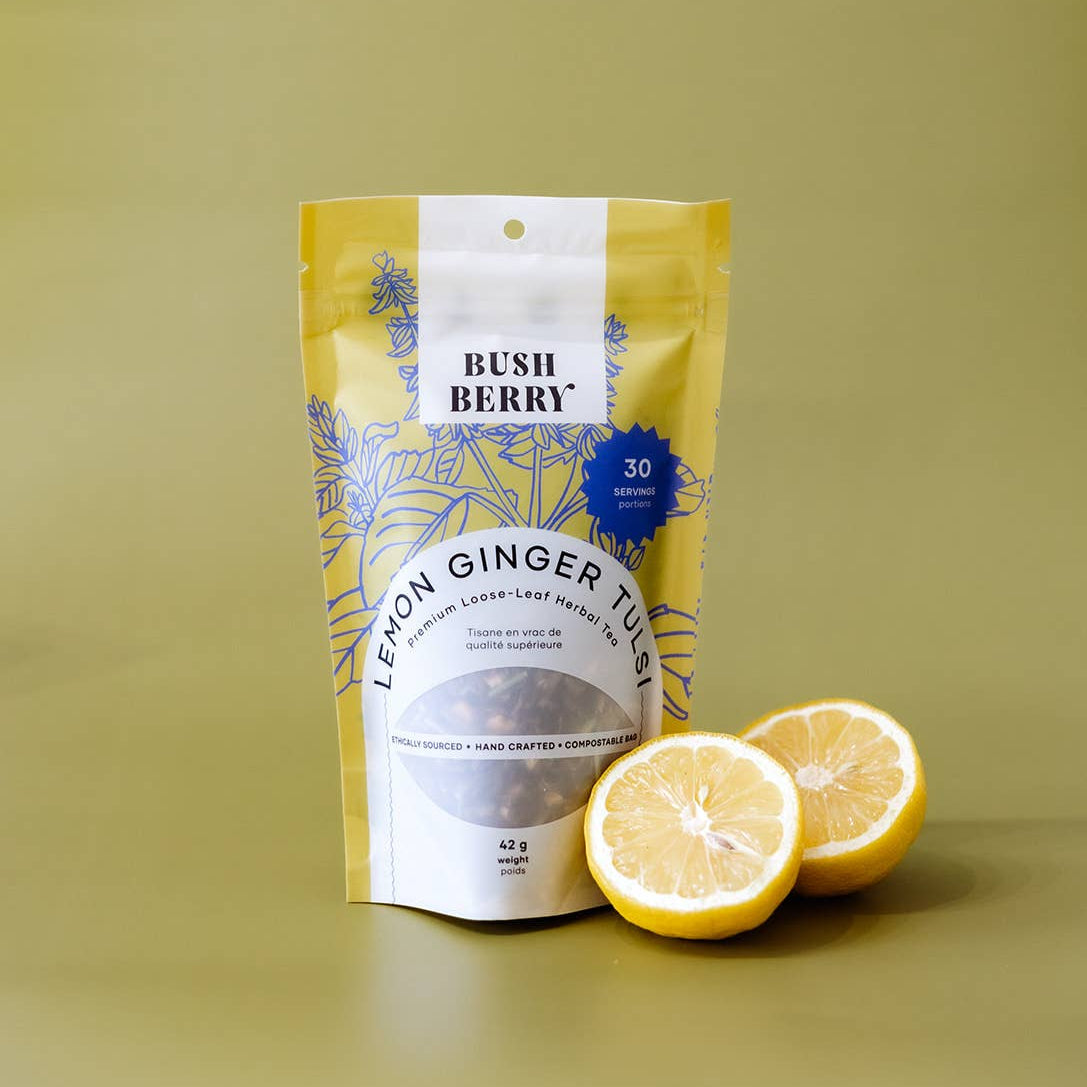 Bag of Bush Berry Lemon Ginger Tea with two lemons on a yellow background