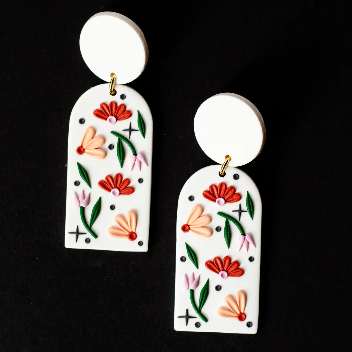 Pair of floral earrings on a black background
