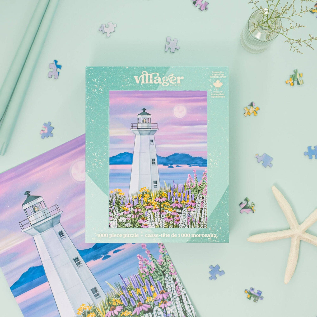 Villager Puzzles Harbour Lighthouse 1000-piece puzzle box on a mint green surface surrounded by scattered puzzle pieces, a starfish, and the poster insert, styled as a coastal gift idea.