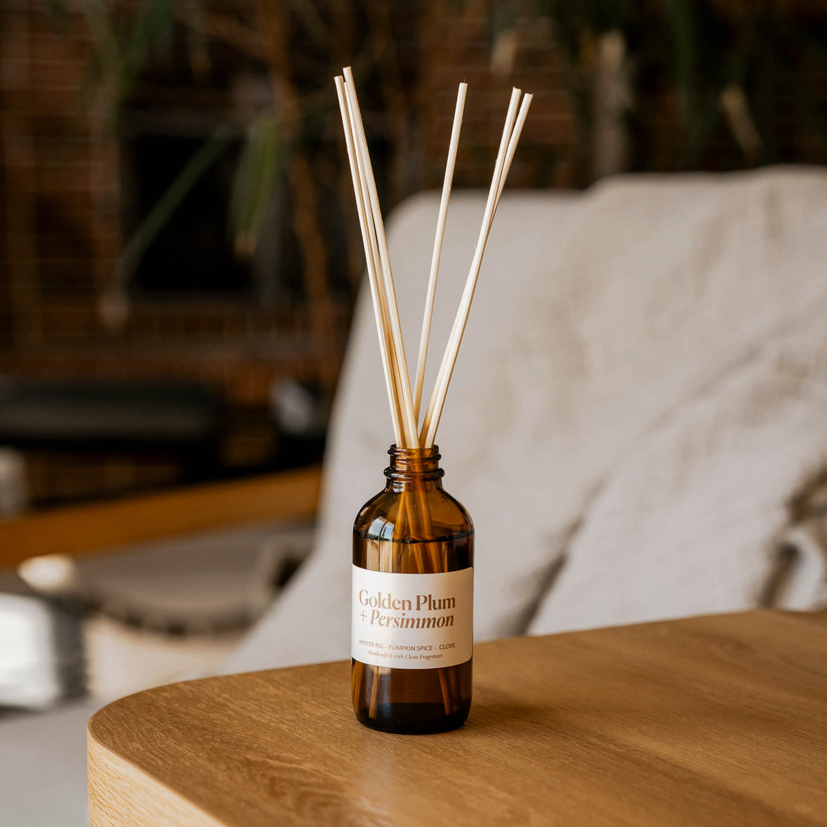 Golden Plum + Persimmon Reed Diffuser. Set up with reeds in a cozy living and diffusing gentle fragrance for 6 months or more.