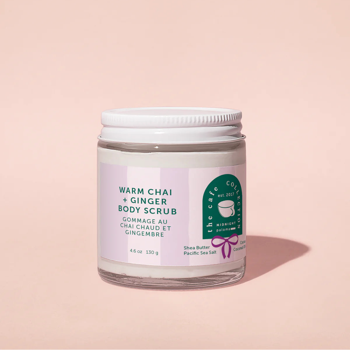 Jar of warm chai and ginger body scrub on a pink background