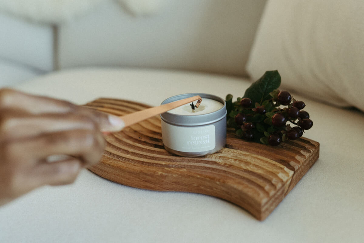 Candle being extinguished on a wooden tray with a blurred background