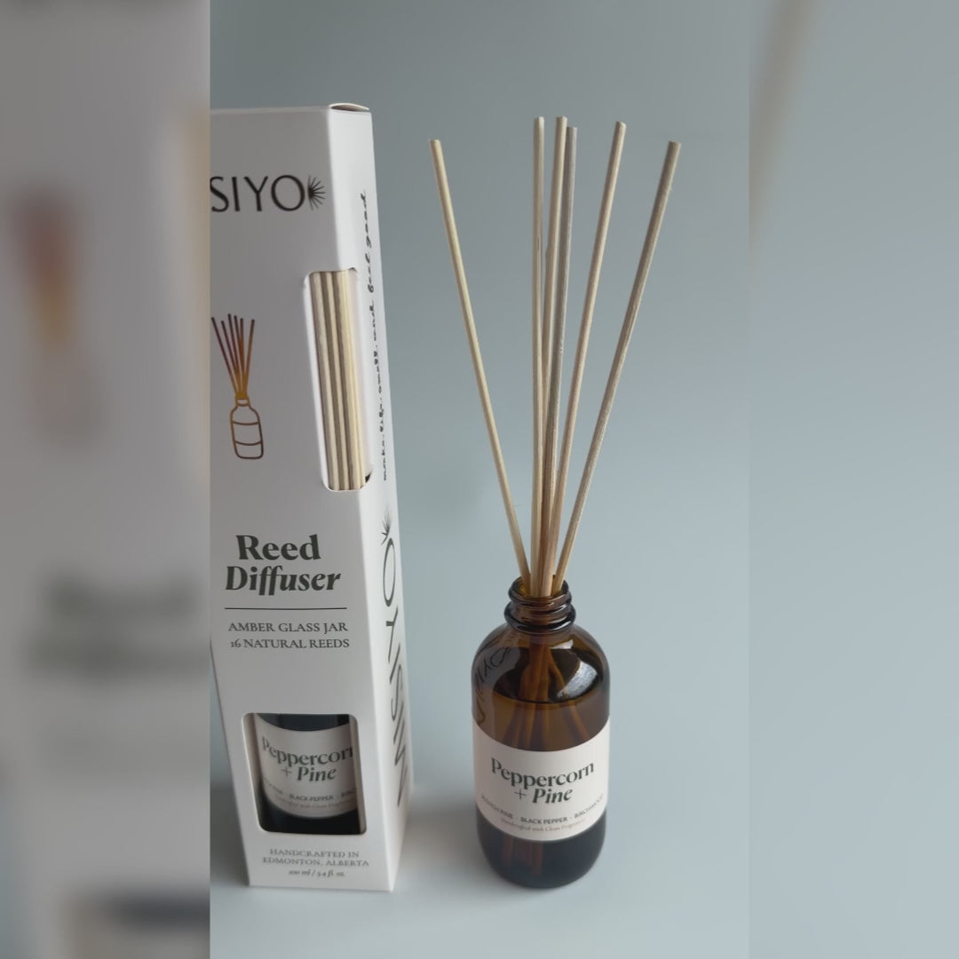 Video showing the product and packaging details of this Peppercorn + Pine reed diffuser from Misyo. A hand shows all angles of the box as well as the set up amber bottle with scented oil and the natural rattan reeds beginning to diffuse into the room.