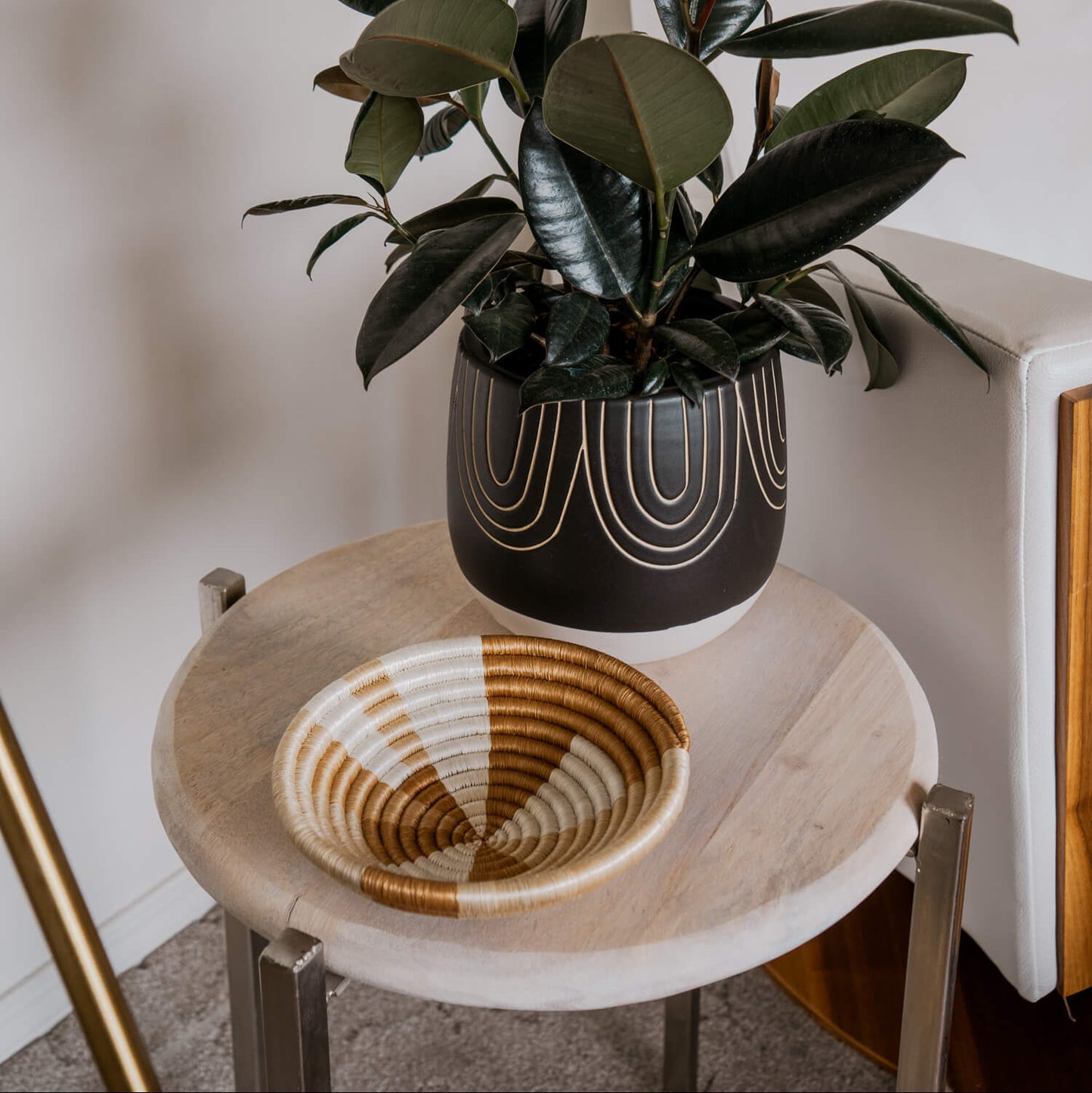 Potted plant on a marble side table with a woven basket