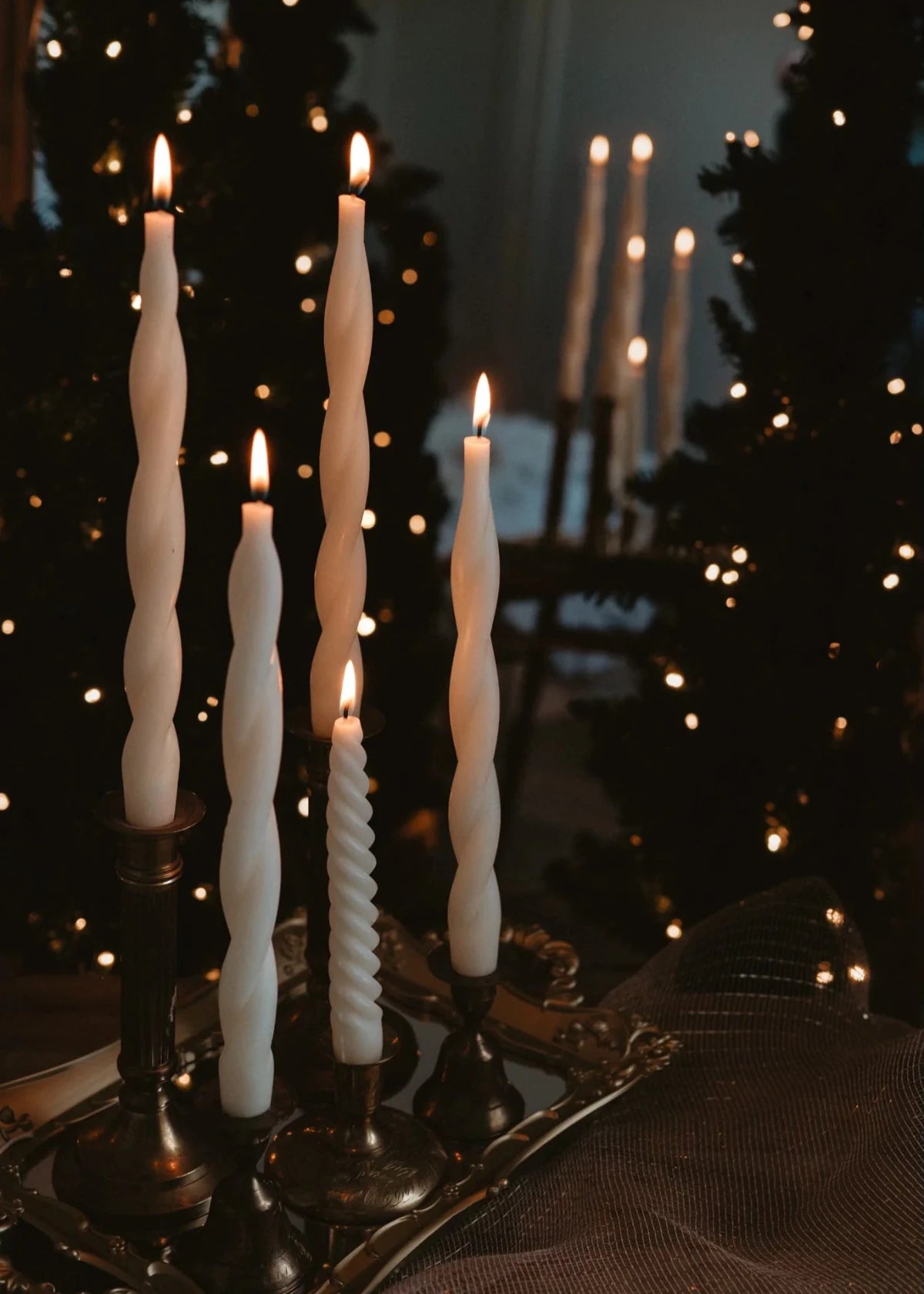 spiral beeswax taper candles burning with twinkle lights